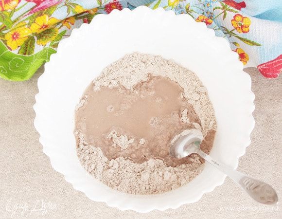 Влить в мучную смесь фруктовый сироп (4 ст. л.) и небольшое количество воды. Начать замешивать тесто. 