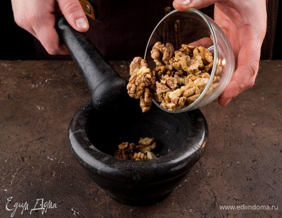 Чеснок порубите на несколько частей, положите в ступку, добавьте большую щепотку соли и немного очищенных орехов. Толките, понемногу подсыпая орехи, пока не получится густая однородная паста.