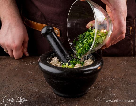Немного кинзы оставьте для подачи. Очень мелко порубите оставшуюся кинзу и зеленый лук, добавьте в ступку вместе с хмели-сунели и имеретинским шафраном.