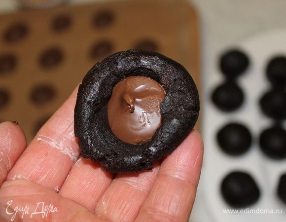 Следующим шагом будет формирование печенья. В каждый шарик положите замороженную начинку из нутеллы, закройте ее краями теста и скатайте шарик так, чтобы начинка осталась внутри.