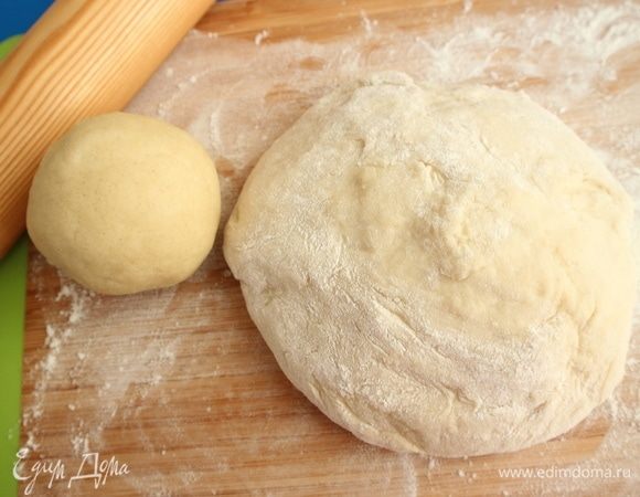 Духовку разогреть до 190°С. Вынуть песочное тесто из холодильника. Дрожжевое тесто вынуть из миски (кастрюли), перемешать на посыпанной мукой поверхности.