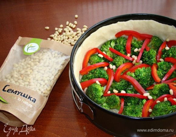 Тесто раскатать и уложить в форму для запекания с высокими бортиками. Уложить брокколи и болгарский перец. Сверху посыпать кедровыми орешками ТМ «Семушка». Орешки очень вкусные и ароматные! Мне они напомнили мое детство, которое я провела на Севере. Вспомнилось, как ездили в лес за кедровыми шишками... Как собирали их, находя в траве, — красивые, слегка покрытые синеватым инеем, напоминающим издалека виноградную гроздь... Кто собирал шишки, тот меня поймет))