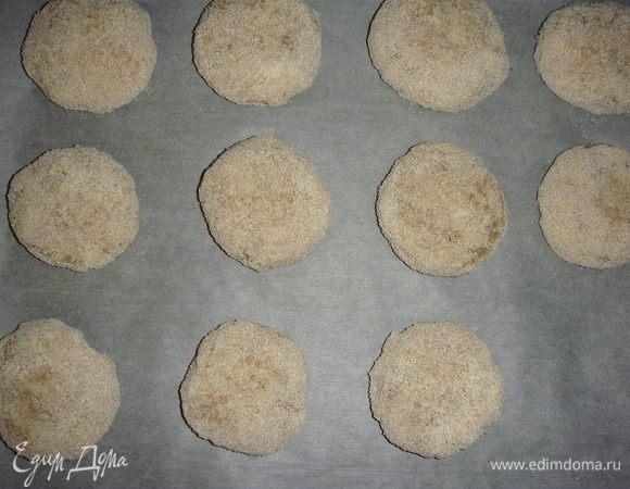 Противень застелить пергаментом и выложить котлетки. Запекать в разогретой до 180°С духовке 10 минут с одной стороны.
