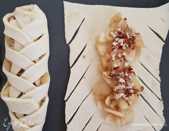 Тесто разрезать на квадраты, примерно 12х12 см. Сделать косые надрезы по краям. В середину нанести немного сиропа и выложить начинку, посыпать орехами ТМ «Семушка». Затем заплести булочки косичкой.