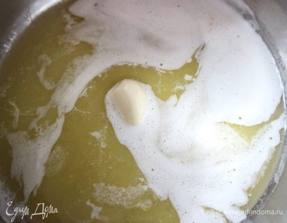 В сотейник положить кусочки масла, зубчик чеснока. Поставить на небольшой огонь. Растопить масло.