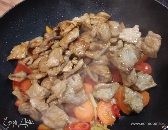 В этой же сковороде (по необходимости добавьте чуть масла) обжарить перец и морковь (недолго — приблизительно минуту) и добавить чили с имбирем. Жарить еще минуту. Выложить в сковороду мясо. И влить соус. Перед тем, как добавить соус, нужно размешать в нем крахмал, чтобы не было комочков. Как только соус окажется в сковороде, он начнет загущаться. Размешайте, чтобы соус обволакивал каждый кусочек мяса и овощей, и снимайте с огня.