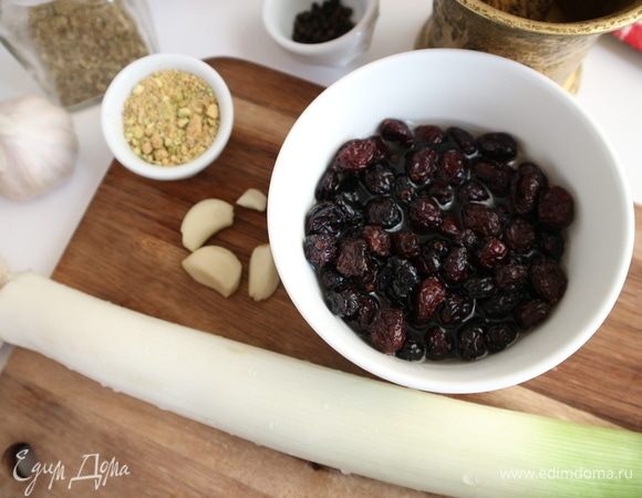 Приготовить начинку. Вяленую бруснику замочить в вине на 40 минут. Порезать на кусочки. Чеснок очистить. Фисташки измельчить неравномерно, чтобы были кусочки мелкие и покрупнее. Порей помыть.