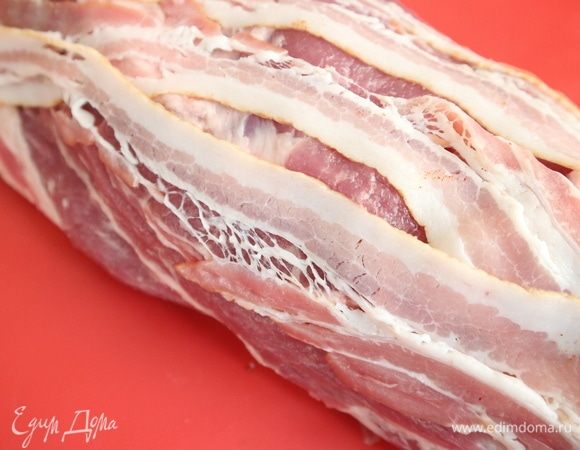 Положить вдоль мясного рулета (с промежутками) оставшиеся несколько кусочков бекона. 