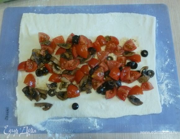 На каждую часть выложить начинку и натереть сверху сыр, свернуть в плотный рулет. Каждый рулет разрезать на 4-6 частей. Перенести на застеленный противень.