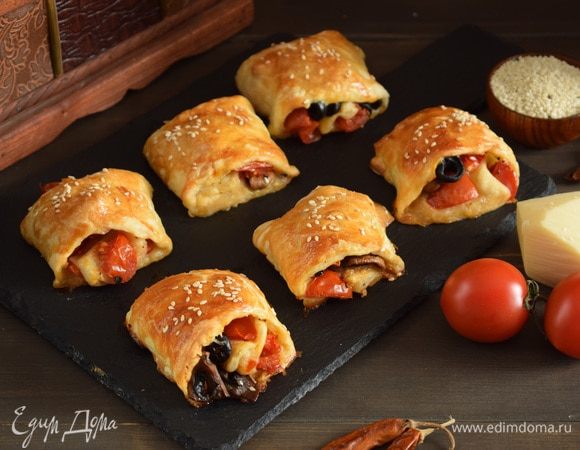 Верх рулетиков смазать взбитым яйцом. Посыпать кунжутом. Поставить противень в духовку (200°C) на 30 минут до золотистого цвета. Приятного аппетита!