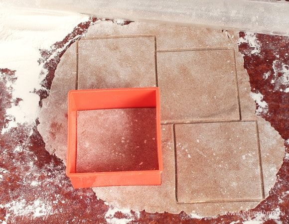 После отведенного времени раскатать тесто на припыленной пшеничной мукой поверхности в тонкий пласт, как для лаваша. Разрезать ножом на квадраты (12х12 см) или вырезать сервировочной формой. Ни в коем случае не делать никаких наколов на заготовках.