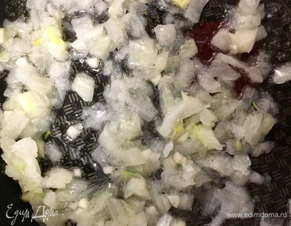 Приготовление котлет начнем с процесса обогащения рыбного фарша разными вкусами и добавками. Сперва очистим одну луковицу среднего размера и мелко порубим. Один зубчик чеснока почистить, раздавить плоской стороной ножа и мелко измельчить. В сковороде разогреть растительное масло и отправить к нему лук и чеснок.