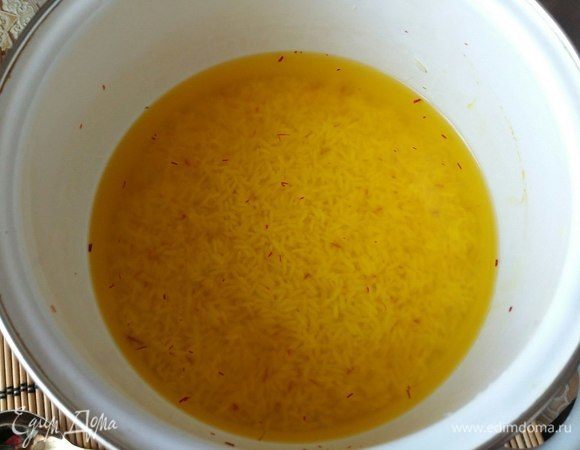 Добавить шафран к рису, поставить на огонь, как закипит, убавить огонь до минимума, посолить и готовить в течение 10 минут. За это время рис впитает воду и начнет набухать. Снять с огня.