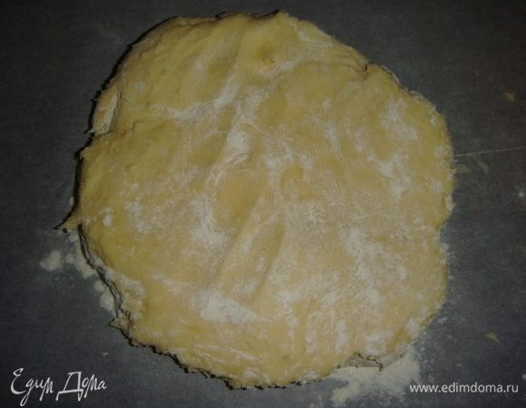Тесто выложить на пергамент слегка посыпать мукой, раскатать круг диаметром чуть больше размера формы, у меня форма диаметром 28 см.
