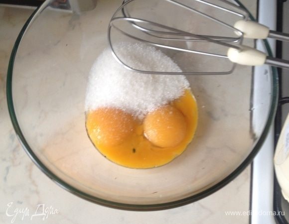 Пока молоко закипает, взбейте желтки с половиной сахара добела с помощью венчика или миксера, всыпьте кукурузный крахмал и перемешайте в однородную массу без комочков.