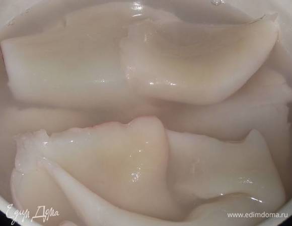 Опустить в кипяток кальмары, накрыть крышкой и дать постоять 10 минут.