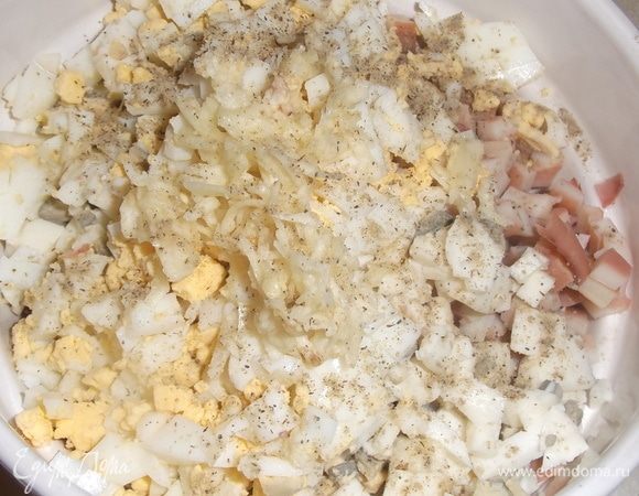 Добавить нарезанное яйцо, натертый на терке или пропущенный через пресс чеснок. Посолить, поперчить. Добавить 1–2 ст. ложки процеженного отвара от кальмаров. Заправить майонезом. Посыпать петрушкой.