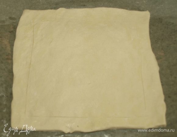 Пласт размороженного теста немного растянуть руками. Наметить ножом края. 