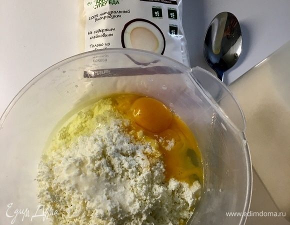 В миску к перетертому творогу добавляем сахар, щепотку соли и вбиваем два яйца.