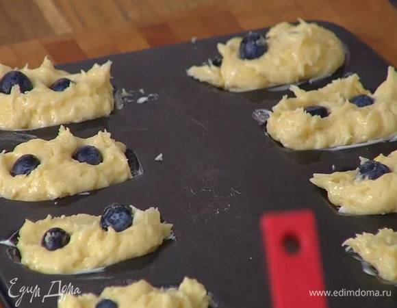 Форму для мадленов смазать оставшимся сливочным маслом, выложить тесто, поместить в каждую формочку пару ягод голубики и слегка вдавить их в тесто.