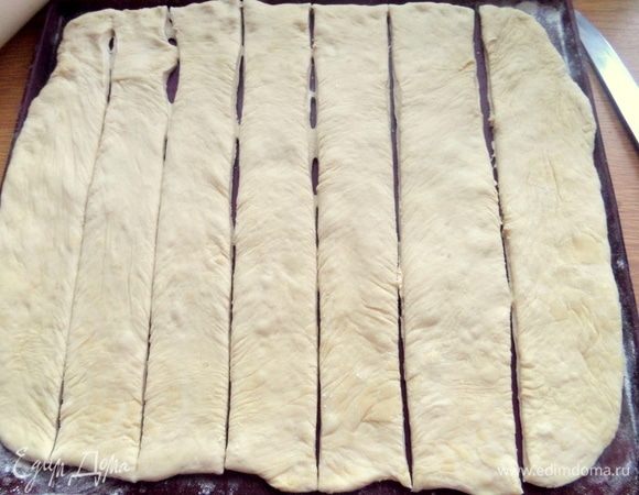 Размять тесто ладонями по столу или по силиконовому коврику с мукой.