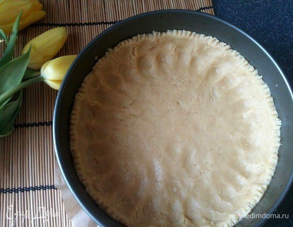 Основное тесто распределить руками равномерно по форме, формируя бортики. 
