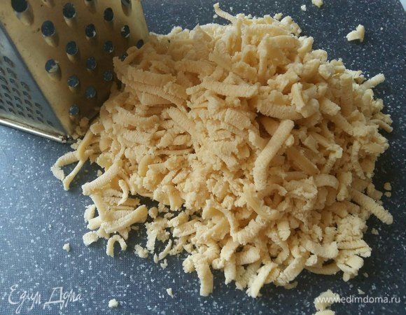 Достать кусочек теста из морозильной камеры и натереть на крупной терке.