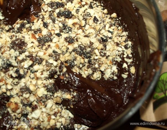 Шоколад растопить с добавлением сливочного масла и сливок, добавить измельченные орехи и изюм. Хорошо перемешать. 