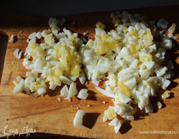 Остуженные яйца очищаем и нарезаем. Кукурузу, яйца, крабовые палочки кладем в глубокую емкость. Нарезаем и добавляем петрушку. Заправляем салат майонезом, солим, перчим. 