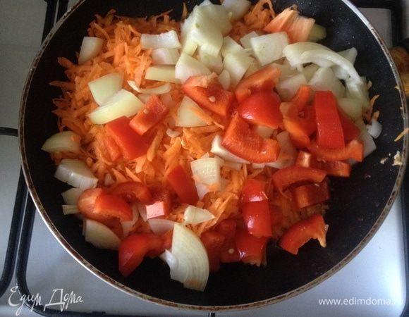 В сотейнике где жарились куриные ножки разогреть растительное масло 2 ст. л. Морковь натереть на крупной терке, лук и сладкий перец нарезать крупными дольками, все вместе  обжарить до золотистого цвета.