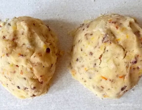 Добавить желток (белок не добавлять, он сделает печенье дубовым). Из апельсина отжать сок и добавить 2 ст. л. апельсинового сока, замесить тесто. Если оно не собирается воедино, добавьте еще соку пока крошки не соберутся. Но при этом оно должно немного крошиться. Разделить тесто на две части.