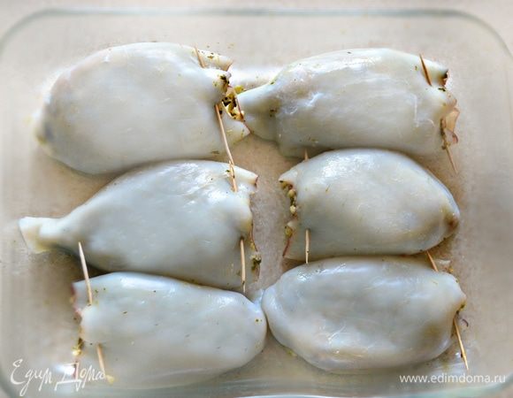 Тушки кальмаров наполните приготовленной начинкой, отверстия закрепите зубочистками.