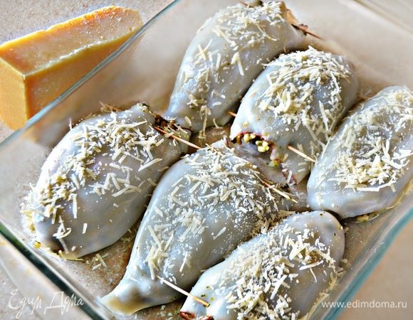 Уложите начиненные кальмары в смазанную маслом форму, посыпьте оставшимся сыром и запекайте в нагретой до 180°С духовке около 20 мин.