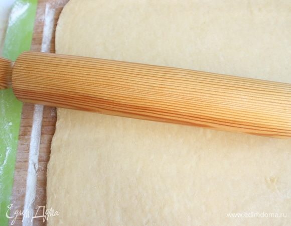 Тесто слегка обмять, положить на рабочую поверхность, присыпанную мукой. Раскатать тесто в прямоугольник 40х60 см.