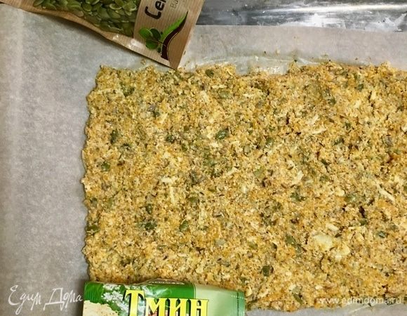 Духовку разогреть до 180°С. Противень выстелить бумагой для выпечки. На него в форме прямоугольника выложить тесто.