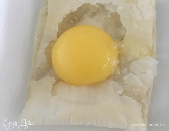 Достать из духовки полуготовые квадраты. Вырезать середину и вылить яйцо. Поставить в духовку на 5-7 минут, до зарумянивания. 