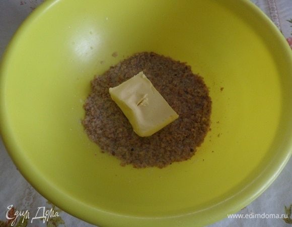 Добавляем в чашку к хлопьям сливочное масло. Перемешиваем.
