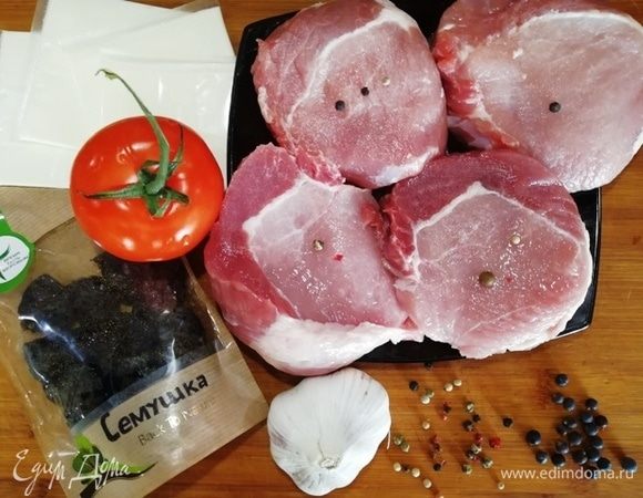 Свинину нарезаем на порционные куски. Подготавливаем остальные ингредиенты. Чернослив я промыла разрезала пополам. Чеснок и помидор нарезала пластинами. 