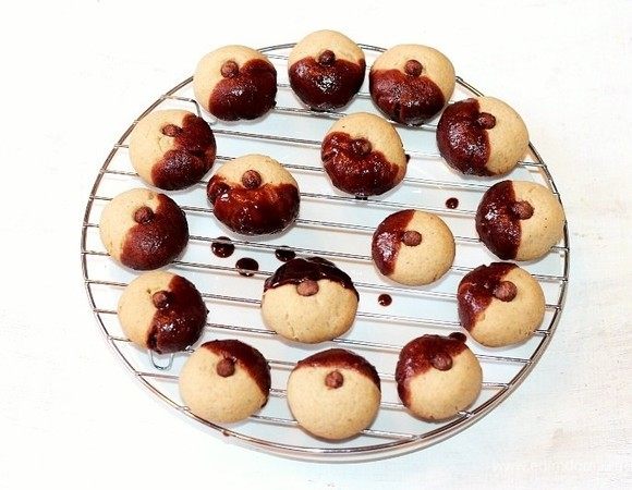 Каждую печенюшку макните в шоколадно-ореховую смесь и выложите на решетку.