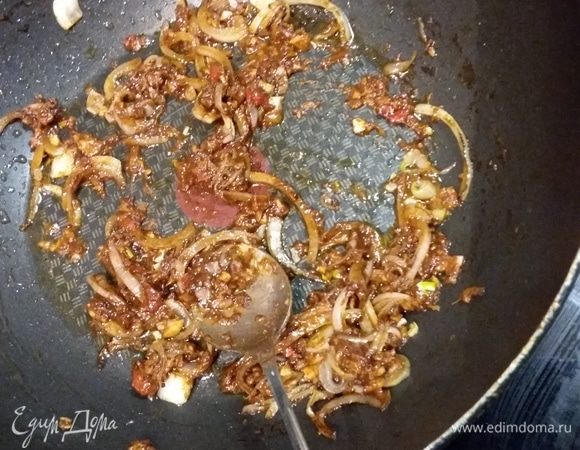 В эту же сковородку выложить нарезанный соломкой лук, обжарить и тут же добавить кашицу из специй. Обжарить полминуты до появления стойкого аромата, влить горячую воду, довести до кипения, тушить 5 минут.