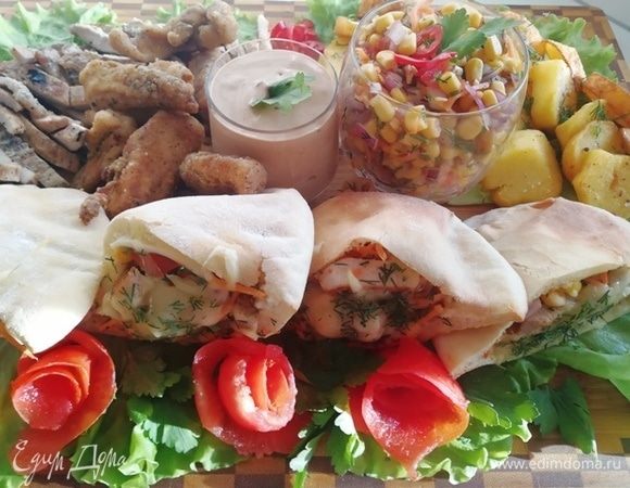 На доску я выкладываю питы, оставшийся салат, острый соус из майонеза, соуса чили и терияки, картофель, поджаренный кружочками, стрипсы куриные и нарезанный стейк.