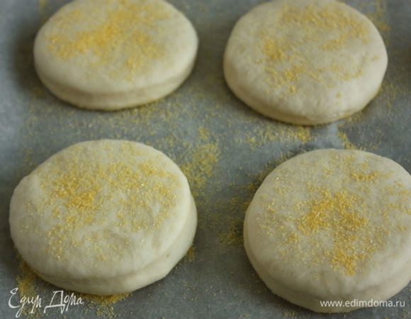 Лист пергамента посыпать полентой. Выложить на него подготовленные кружочки теста и сверху на них посыпать оставшуюся поленту. Накрыть заготовки полотенцем и оставить на расстойку, на 30 минут.