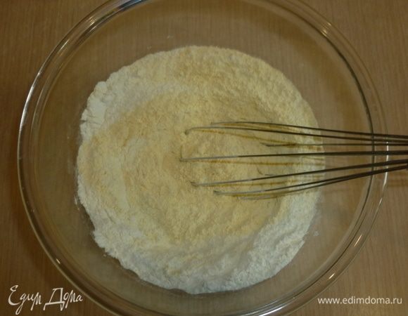 Разогреть духовку до 200°С. Квадратную форму (где-то 25х25 см) застелить пергаментом. В большой миске смешать оба вида муки, разрыхлитель, добавить щепотку соли.