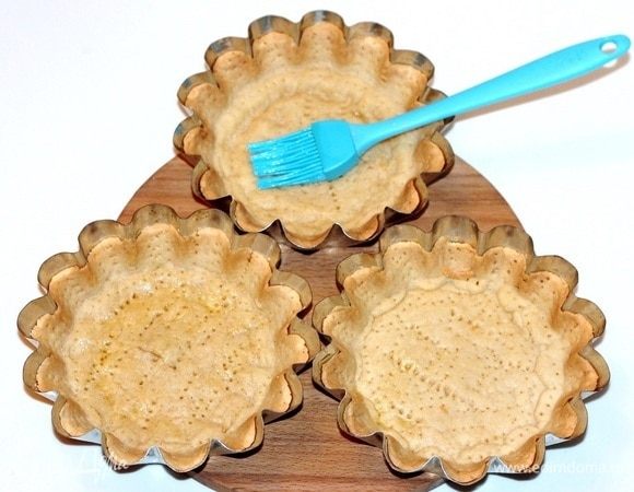 Через час, выпекаем заготовки в разогретой до 180°С духовке. Время выпекания до легкого румянца стенок коржа, ~15 минут. Не пересушите! Испеченные тарты смазываем внутри растопленным сливочным маслом. Охлажденные корзиночки, легко отходят от формочки. Можно их вынуть, а можно оставить, но убедится, что отходят обязательно.