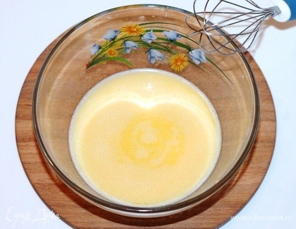 Когда масло растопится в молоке, снимаем сотейник с плиты. Добавляем 3 ст. л. горячей масляной смеси к яичной, постоянно помешивая венчиком. Затем постепенно добавляем остальное, так чтобы яйца не свернулись.