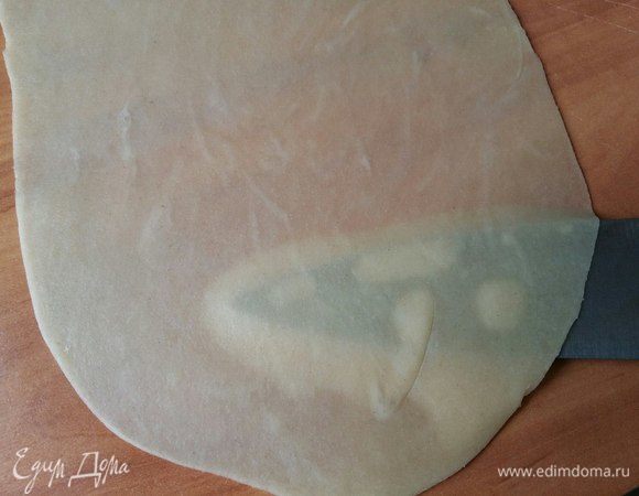 Начинаем формировать пирожок. Раскатать кусочек теста размером примерно 15*25 см (+/-2 см). Раскатываем так, чтобы тесто было практически прозрачным. Тесто эластичное, податливое, не рвется. Как видно на фото, сквозь тесто виден нож.