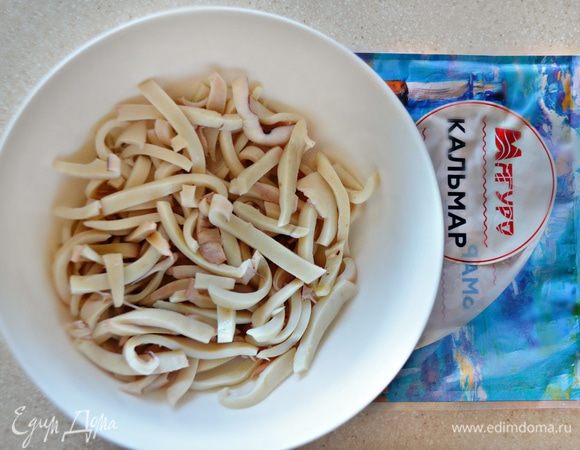 Уложите тушки кальмаров в кастрюлю, залейте подсоленным кипятком и проварите не больше 1 мин. Воду слейте. Кальмары остудите и нарежьте брусочками.