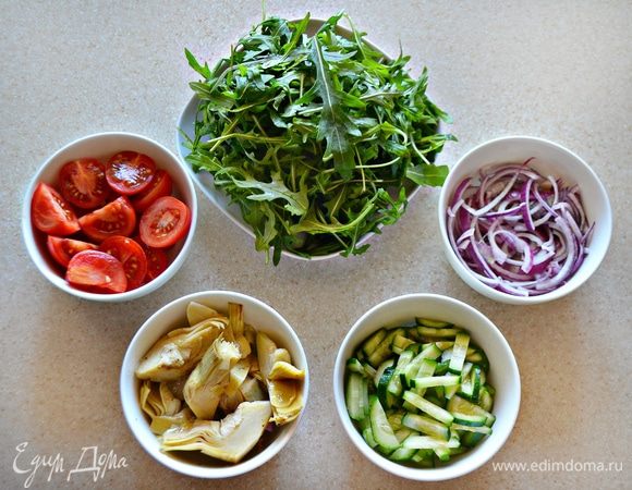 Овощи и руколу хорошо промойте, обсушите с помощью бумажных полотенец. Черри разрежьте пополам (крупные — на три части или четвертинки), огурцы — тонкими брусочками. С артишоков слейте масло, крупные кусочки разрежьте пополам или на несколько частей. (У меня была баночка 285 г вместе с маслом). Лук нарежьте тонкими полукольцами, поместите в пиалу и залейте на 5 мин. бальзамиком.