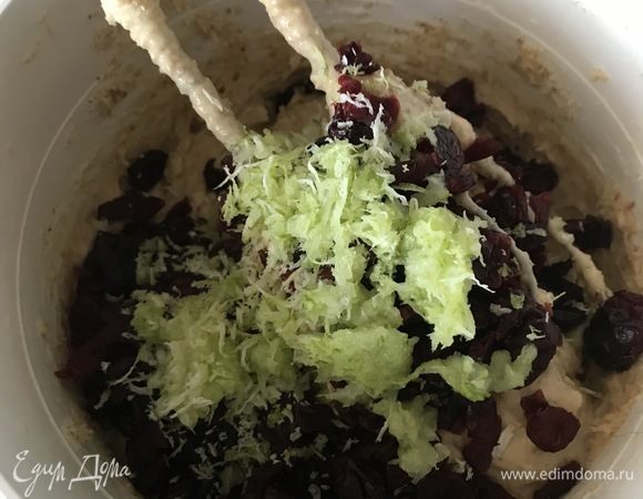 Затем добавляем измельченные орехи, изюм (у меня была вяленая клюква). Можно добавлять любые сухофрукты по вкусу.
Добавляем цедру лимона (у меня был лайм) и вмешиваем это в тесто. Я мешаю все миксером на малой скорости.