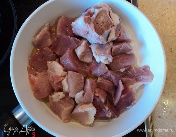 В раскаленную сковородку.
Суть — именно в уже горячую, дабы скорей начало поджариваться, а не тушиться.